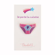 Charger l&#39;image dans la galerie, un pin&#39;s ou une broche en forme de culotte wonderwoman, de couleur rose clair et rose foncé. Celui-ci est accroché sur son support. Un accessoire de mode idéal pour les vêtements ou les sacs à l&#39;occasion des droits de femmes, de la fête des mères ou pour de futurs evjf.
